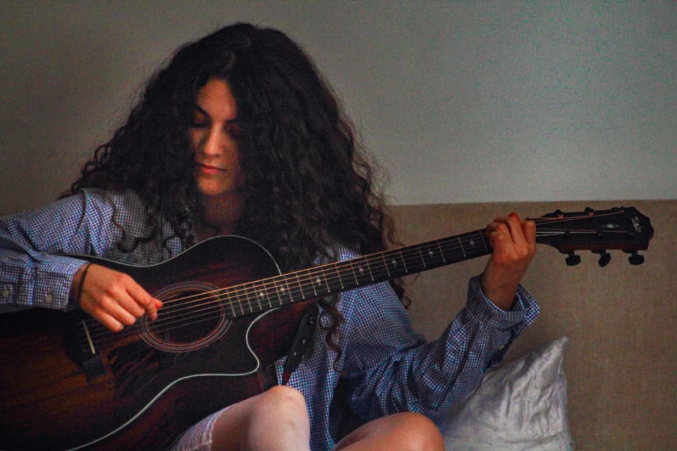 ATARAH playing acoustic guitar — close-up